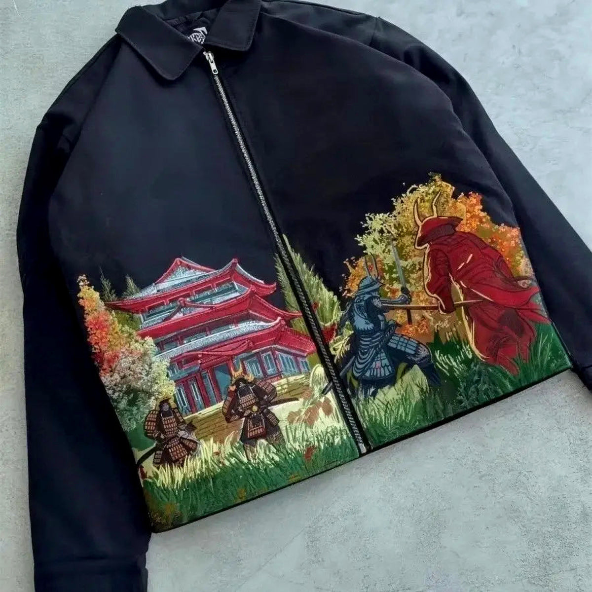 Black Japanese samurai embroidered zip jacket laid flat, full front artwork