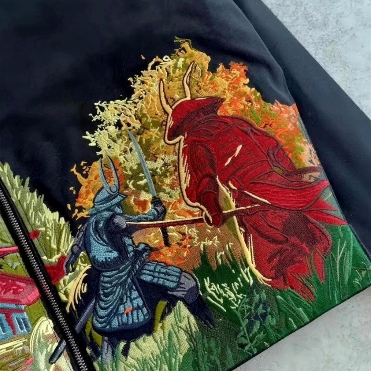 Close-up of blue and red samurai artwork on black jacket