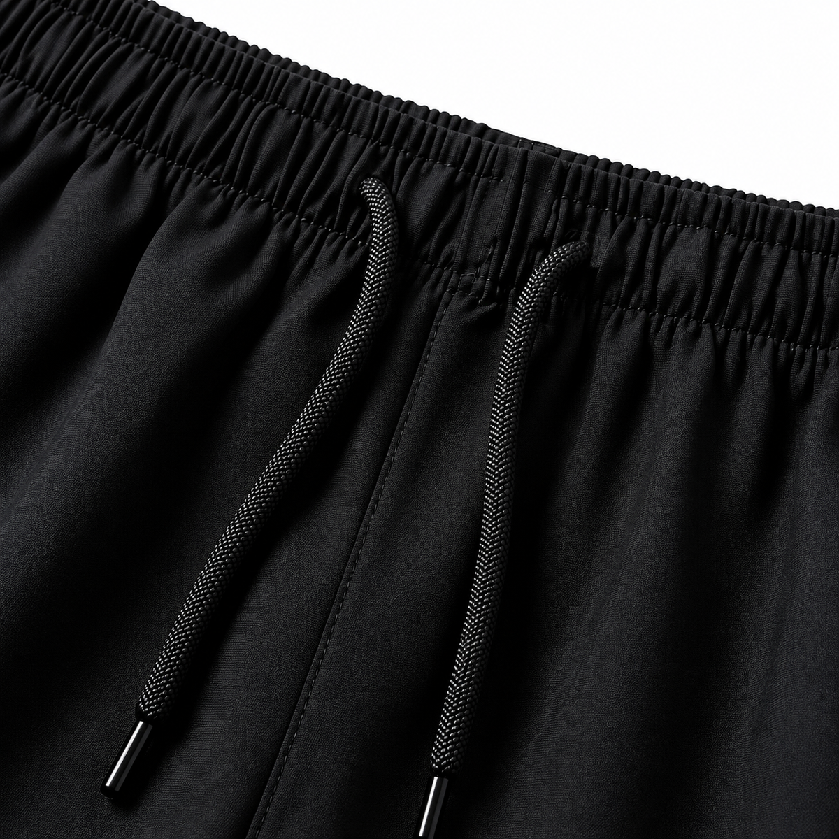 Close-up of the black shorts’ gathered elastic waistband and two black drawstrings.