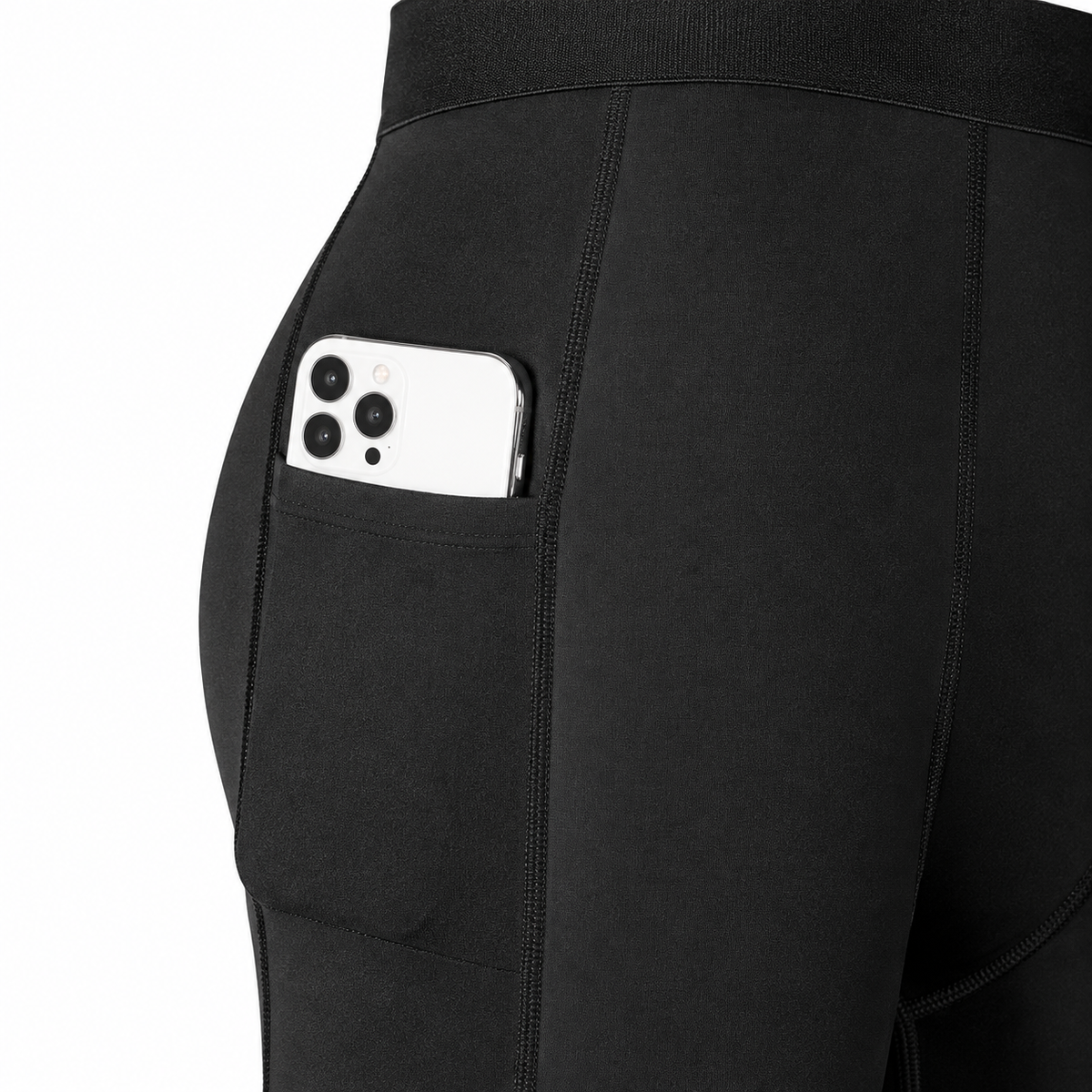 Close-up of the black compression shorts’ side pocket and dark seams; phone prop is not included.