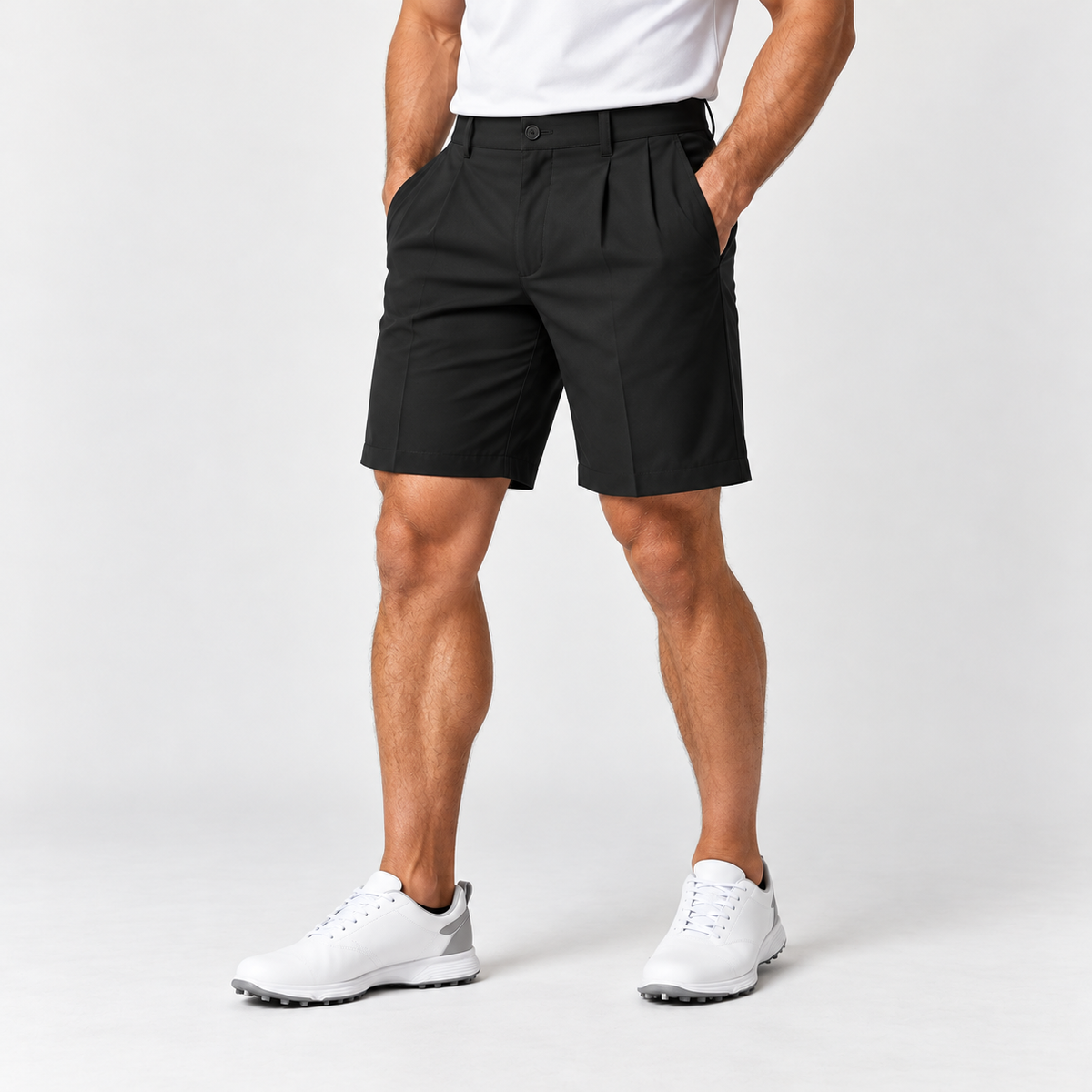 Black men's golf shorts on male model, pleated front with belt loops and slanted pockets, white polo