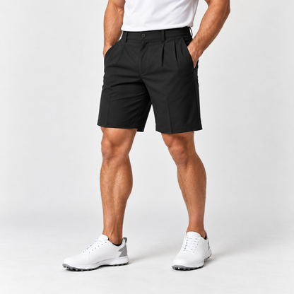 Black men's golf shorts on male model, pleated front with belt loops and slanted pockets, white polo
