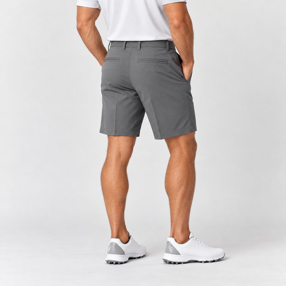 Grey men's golf shorts on male model from behind, rear welt pockets